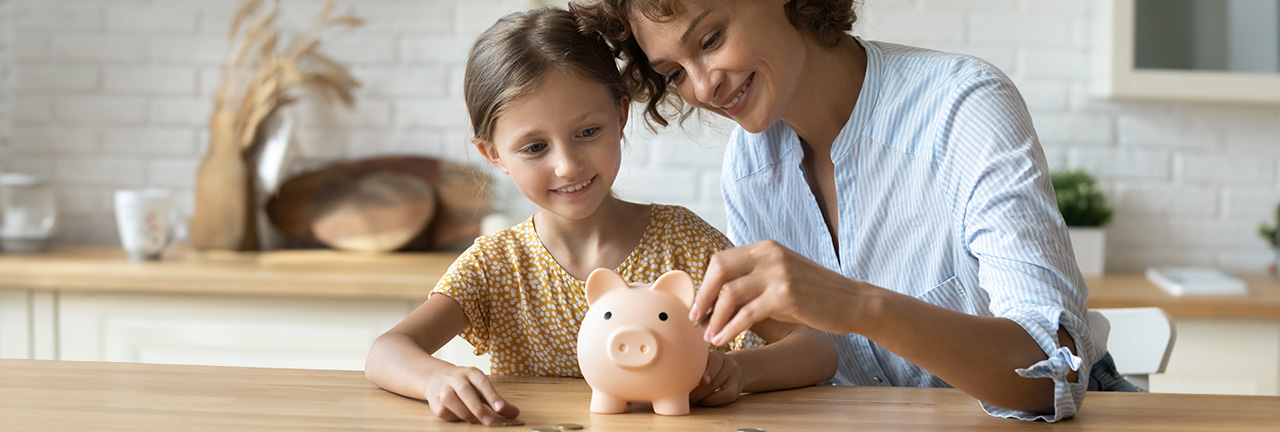 A mother and daughter with a piggy bank saving money